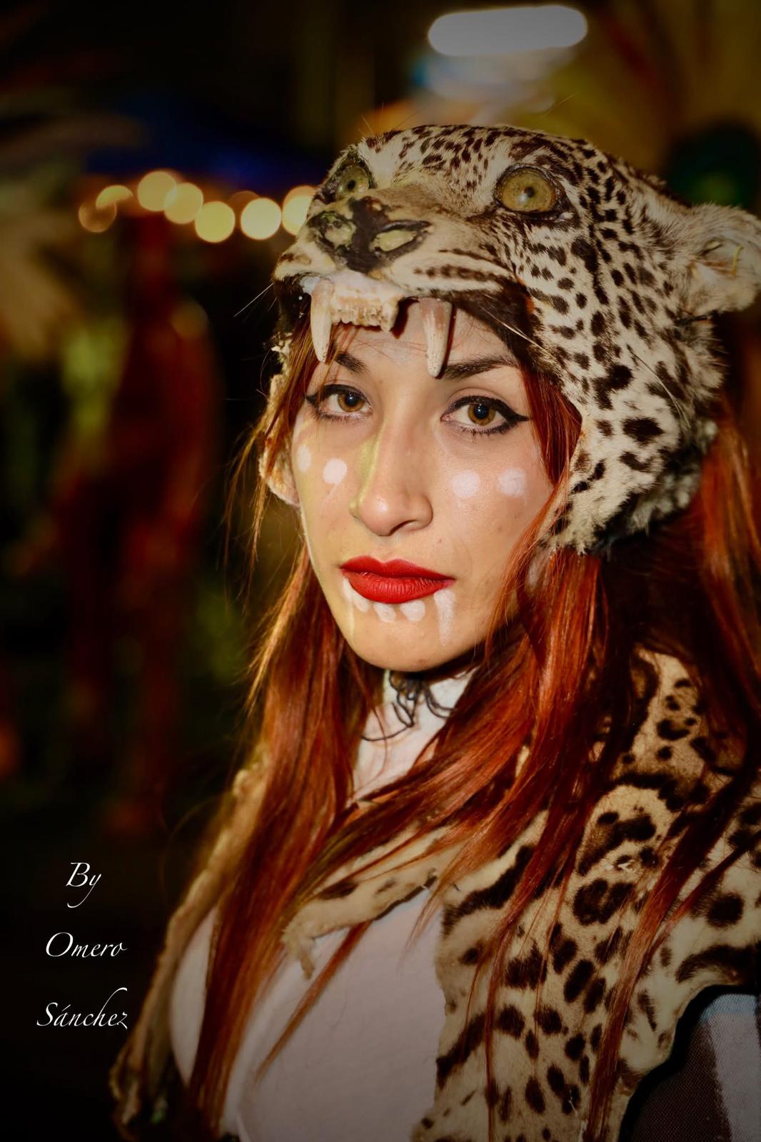Woman in jaguar headdress with ceremonial face paint at night